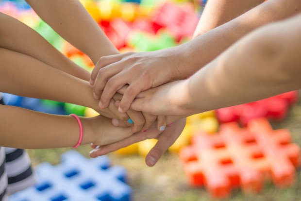 Symbolbild: mehrere Kinderhände treffen aufeinander